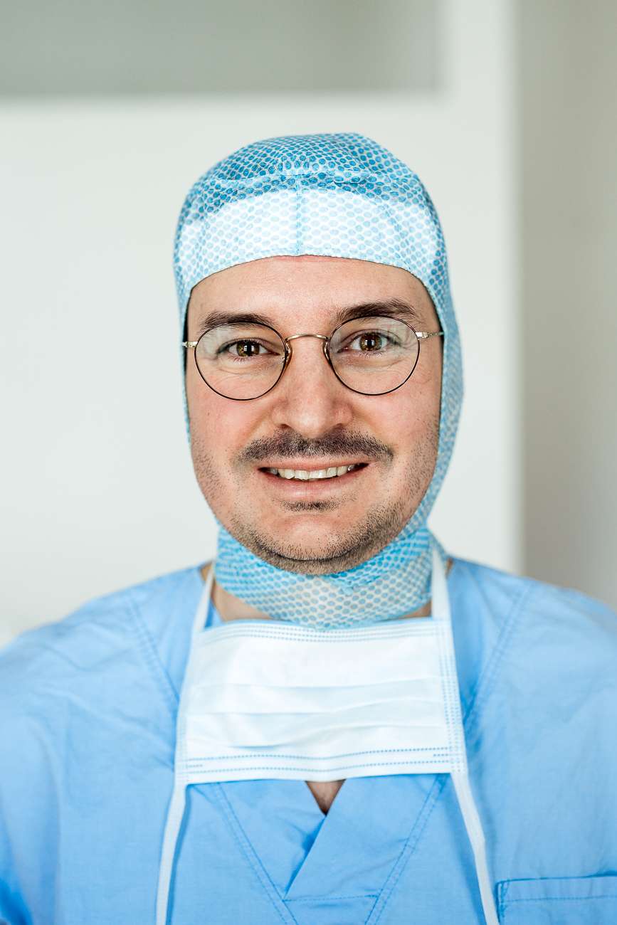 Dr. Figl mit OP-Maske und Kopfbedeckung